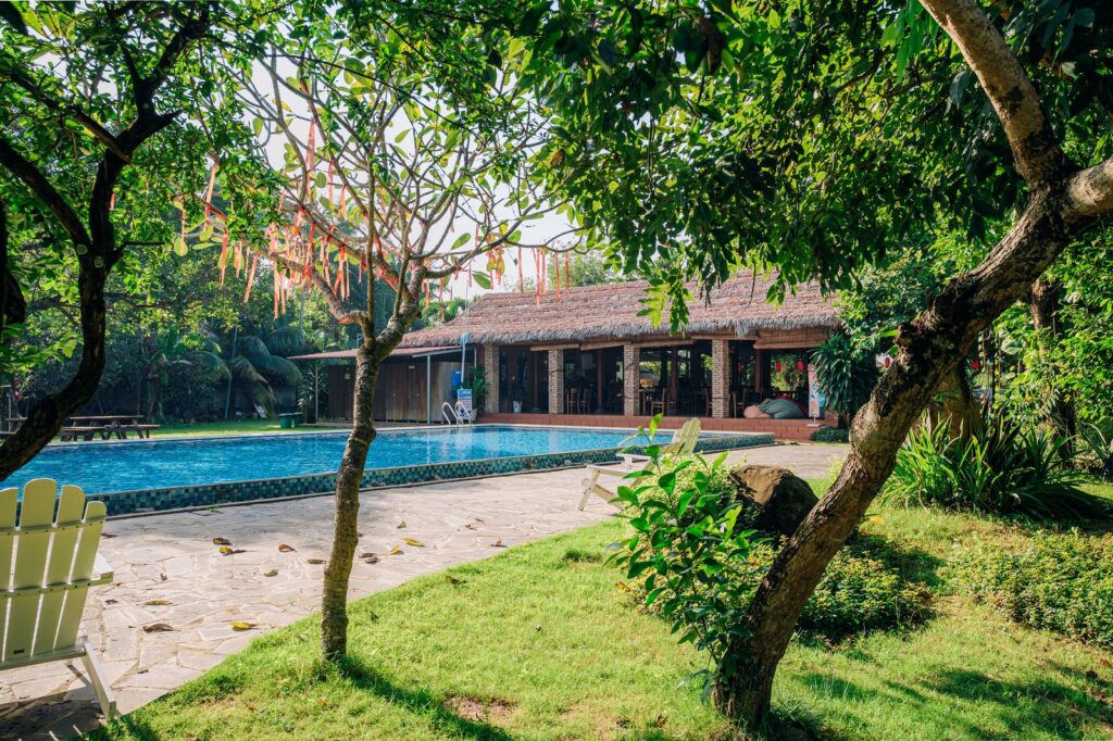 Khu vực hồ bơi xanh mát cạnh nhà hàng mái lá truyền thống tại Haan Boutique Resort.
