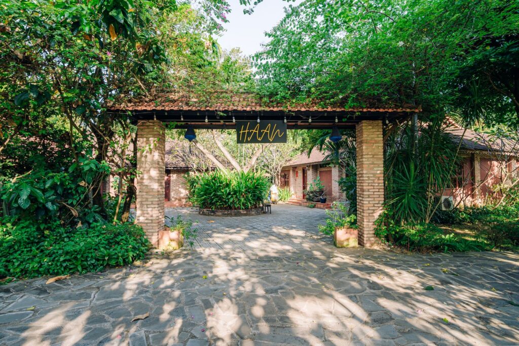 Cổng vào Haan Boutique Resort với kiến trúc gạch nung và không gian xanh mát tại Thủ Đức.