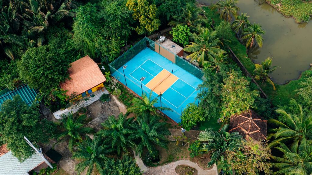 Sân tennis tiêu chuẩn ngoài trời bao quanh bởi cây xanh tại khu nghỉ dưỡng Haan